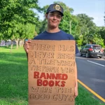 Adam holding a sign