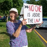 woman holding no one is above the law sign