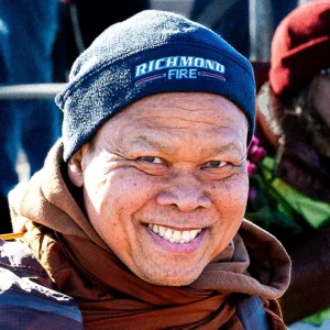 A venerable Buddhist monk waves crossing the Manchester Bridge into Richmond, VA.