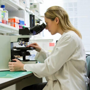 Doctor looking through microscope.